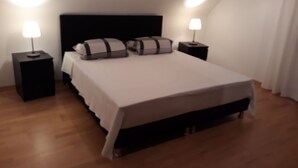 A bedroom with a bed, two bedside tables with lamps, and a sloped ceiling. - AhrHeim Brave new apartment on the Ahr (Bad Neuenahr)