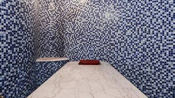 Relax in a stylish room with a unique mosaic tile pattern, a central table, and a curved ceiling.
