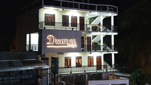 Un edificio de varios pisos con un llamativo letrero que dice 'Dreamers Lodge'.