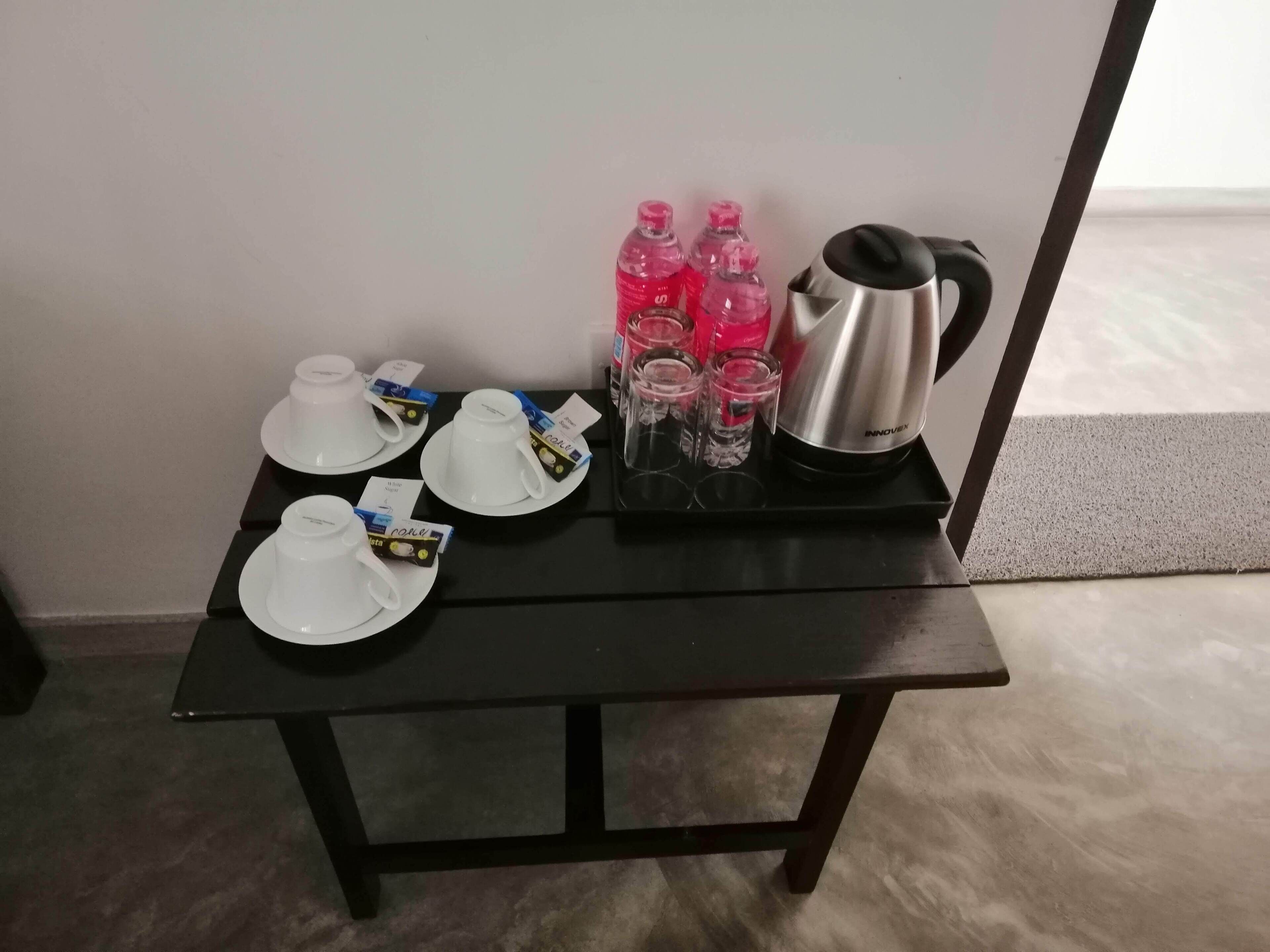 Ein Tisch mit Tee-Service, Tassen und einem Wasserkocher.
