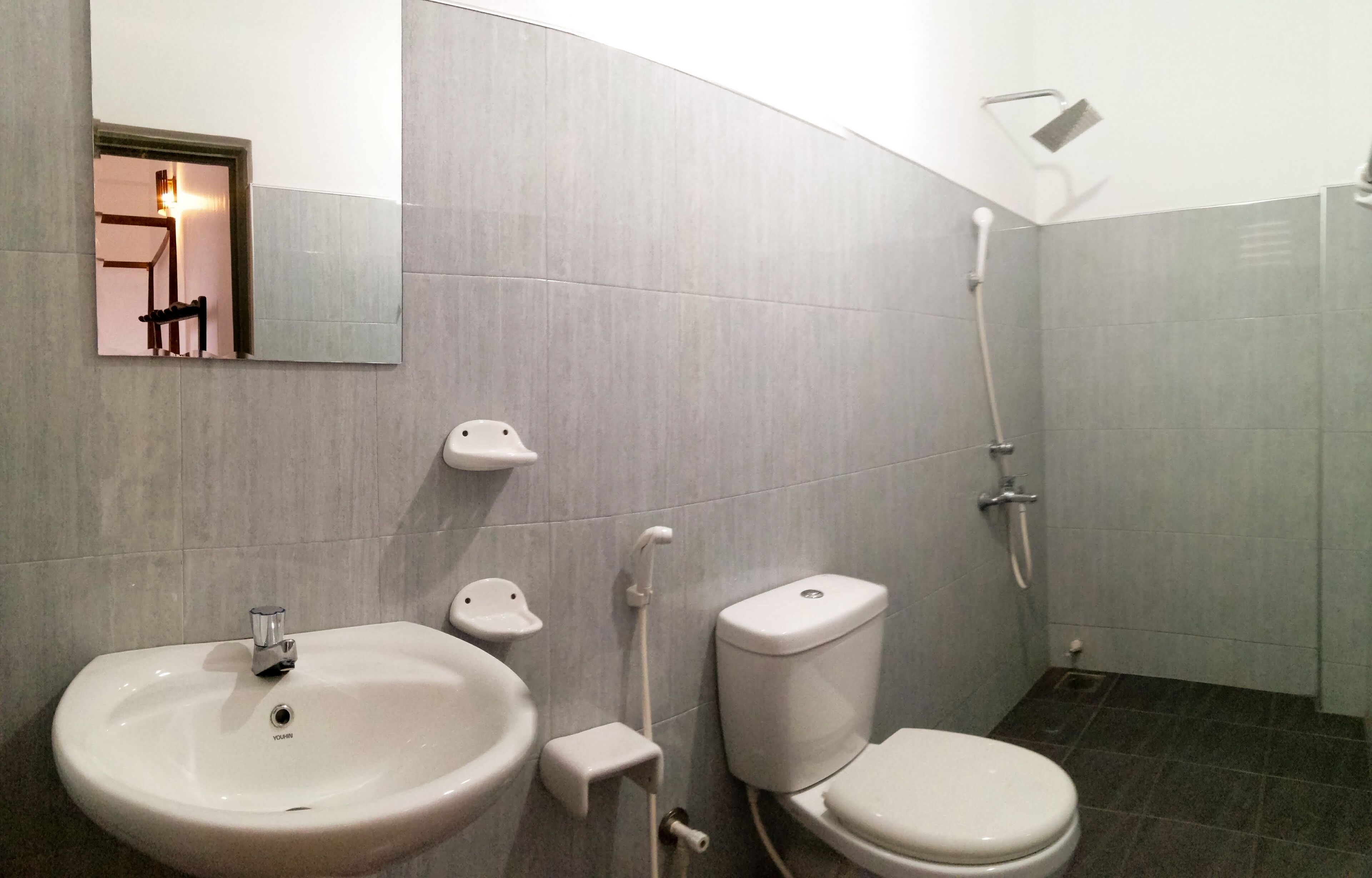 Un baño con lavamanos, inodoro y ducha.