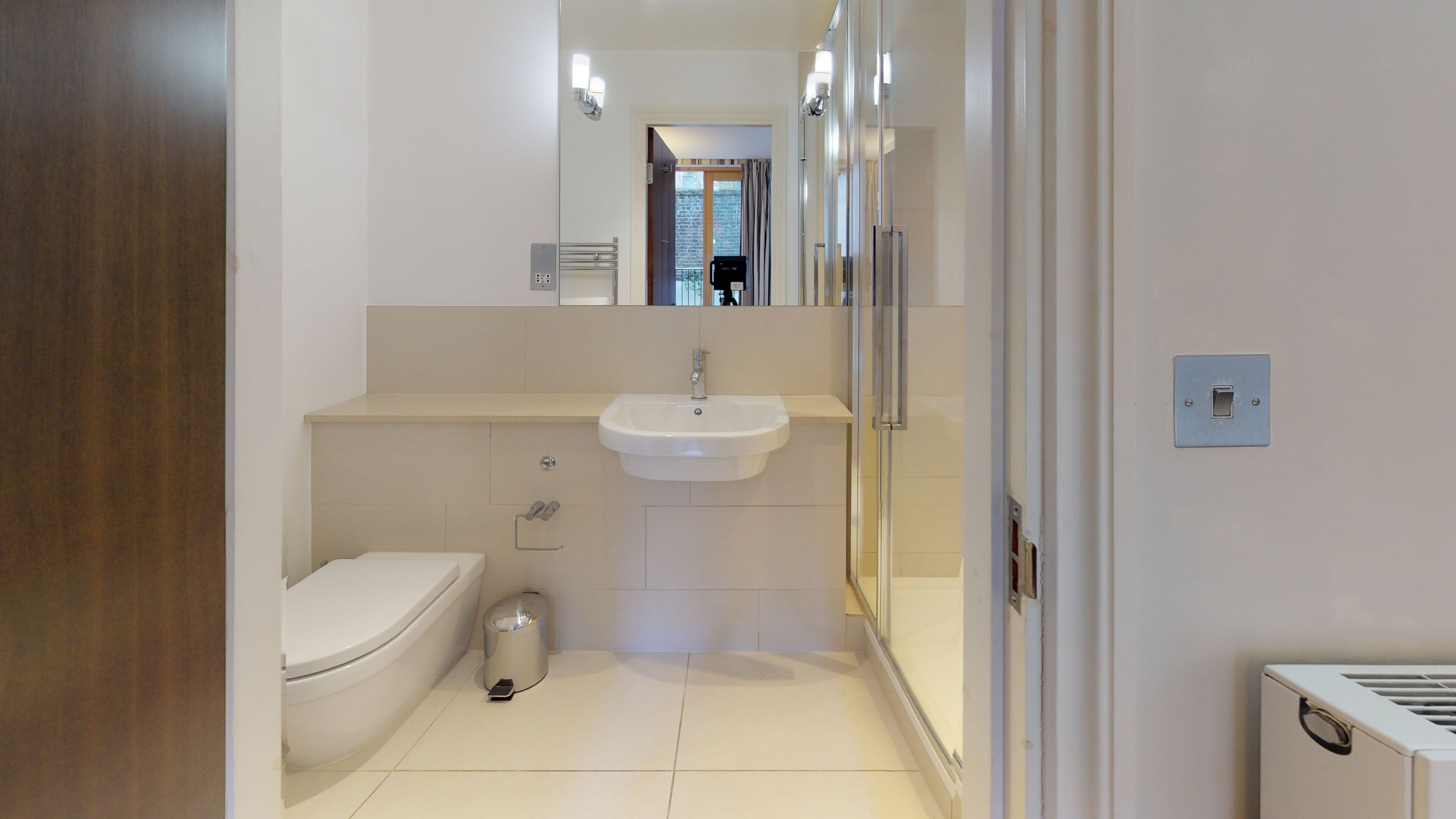 Un baño moderno con inodoro, lavabo y espejo.