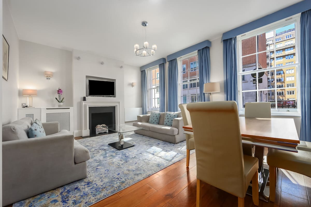 A modern living room with a sofa, a dining table, and a TV.