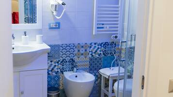 Ein Badezimmer mit Waschbecken, Bidet und einer Duschkabine.