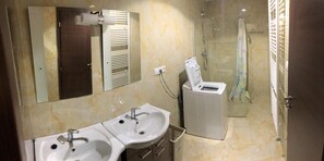 A bathroom with two sinks, a mirror, a shower, and a toilet. - Apartmanovy wellness garni hotel relax (Senec)