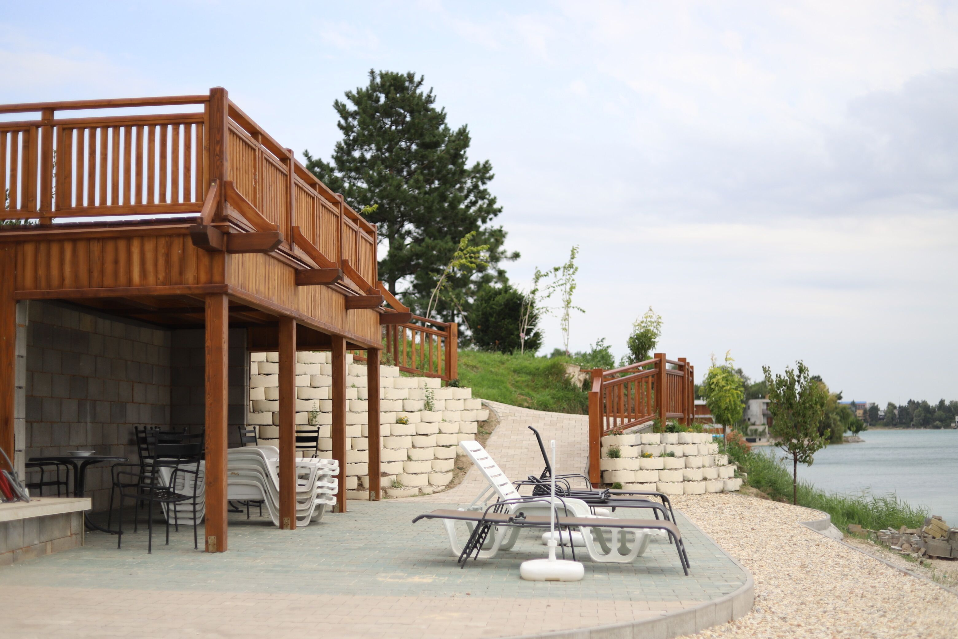Una terraza de madera con mobiliario exterior y zona junto a la piscina.