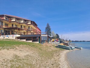 A hotel with multiple balconies, a beachside location, and a view of the water. - Apartmanovy wellness garni hotel relax (Senec)