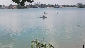 Ein ruhiger See mit Booten und Menschen.