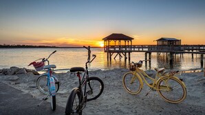 A beach with bicycles and a pier. - Whelk Come Inn | Charming Cottage, Near Beach! (Tybee Island)