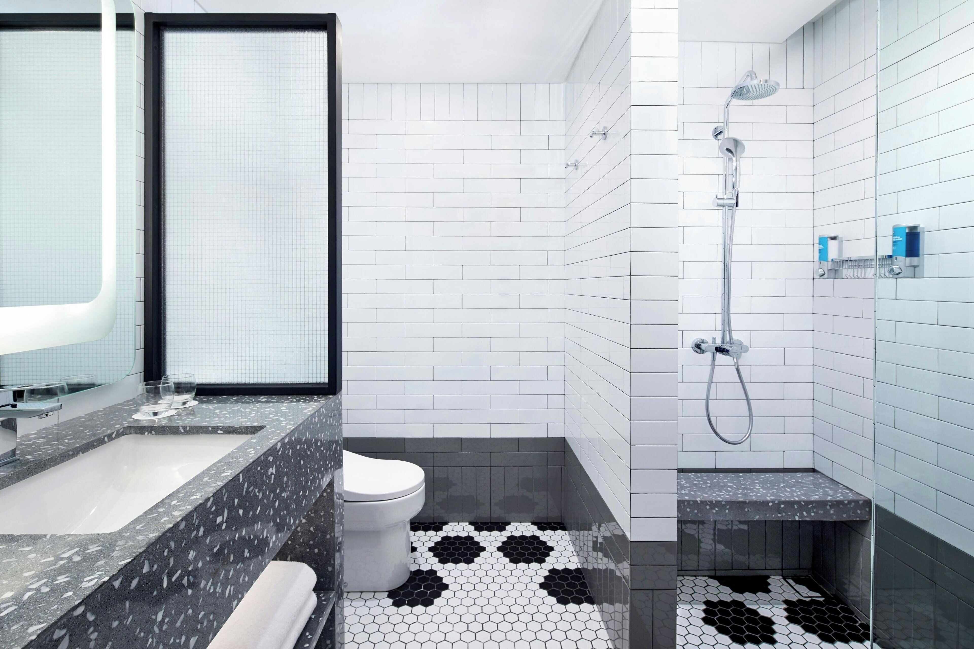A modern bathroom with a bathtub, toilet, and shower area.
