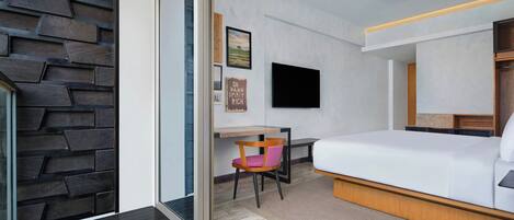 Een moderne hotelkamer met een bed, een bureau en een stoel.