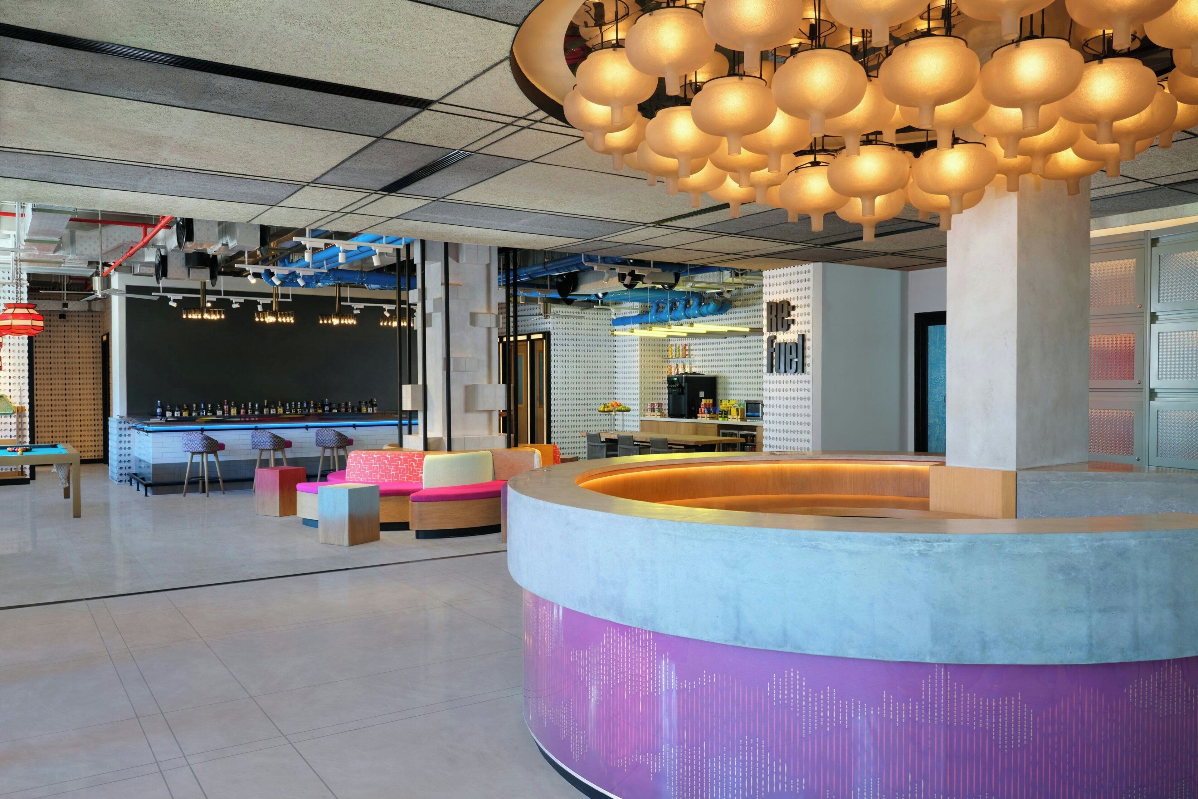 A modern interior with a bar area, seating, and a unique ceiling light fixture.