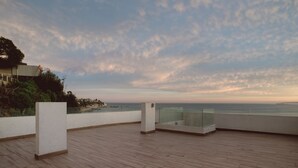 A wooden deck with glass railings overlooking a coastal area. - Zen Surf Concon (Concon)