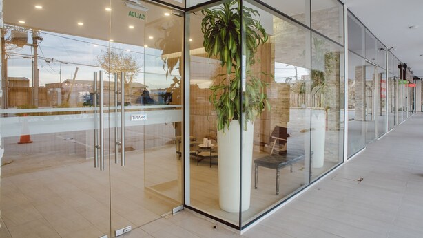 A modern building with glass walls, a large potted plant, and a sign reading "TIRARE". - Zen Surf Concon (Concon)