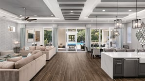 Un amplio espacio de sala con un gran sofá, una mesa de comedor y una isla de cocina.