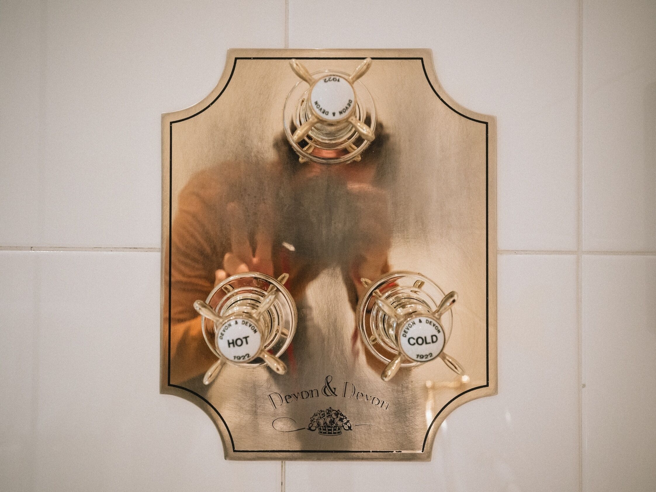 A brass thermostat with three temperature settings: hot, cold, and a central setting.