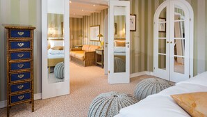 Una habitación con una cama, un aparador y una puerta que da a otra habitación.