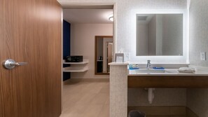 A modern bathroom with a wooden door, a white sink with a mirror, and a towel on the counter. - Holiday Inn Express & Suites Marion by IHG (Marion)