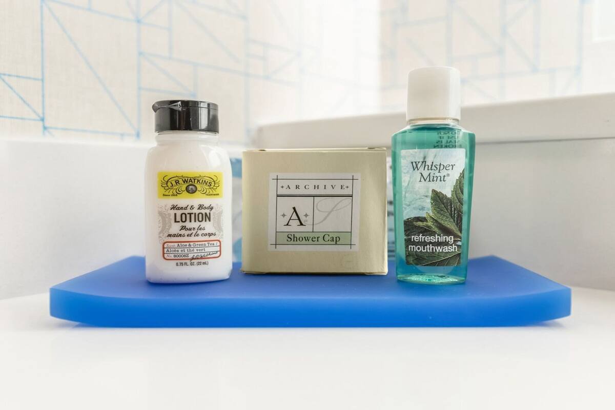 Trois articles de toilette : un flacon de lotion, un bonnet de douche et un flacon de bain de bouche.