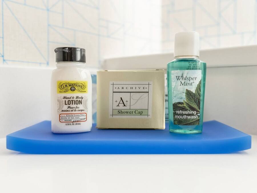 Trois articles de toilette : un flacon de lotion, un bonnet de douche et un flacon de bain de bouche.