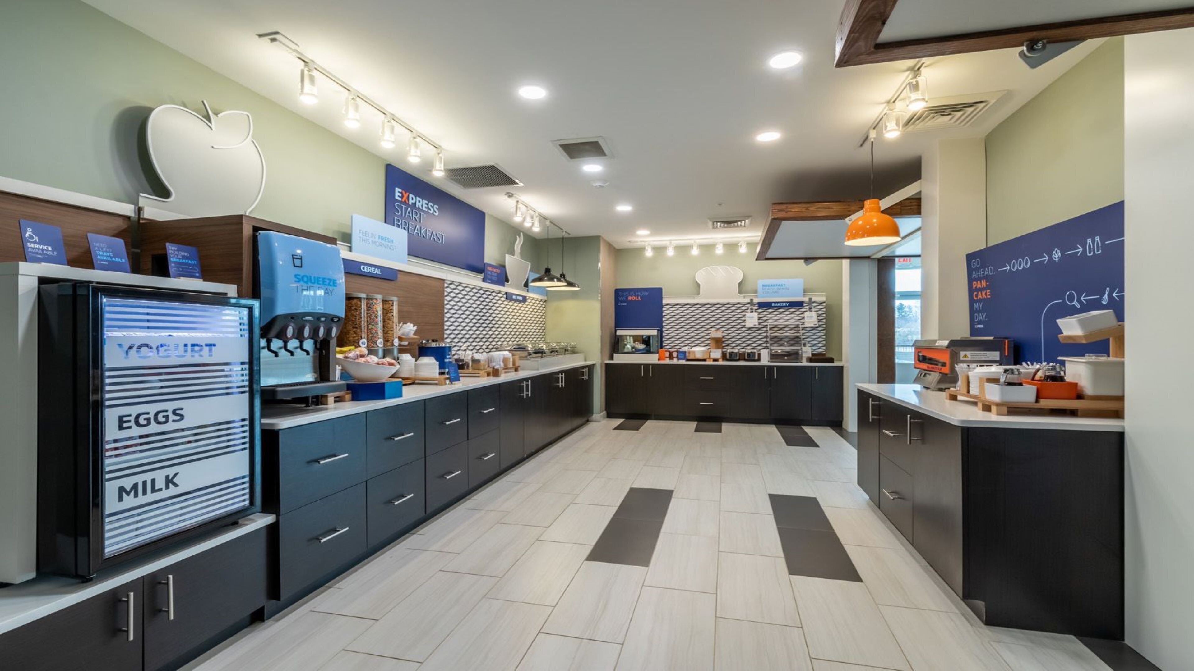 A modern breakfast area with a yogurt machine, eggs, and milk dispenser, a coffee station, and a bakery section.
