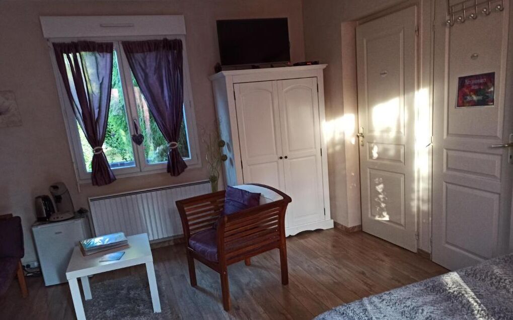 A room with a wooden chair, a small table, a cabinet, and a door.