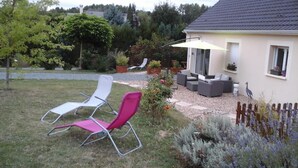 A patio area with outdoor furniture, a pergola, and a garden with various plants. - Chambre et Appartement Zen de Beauval (Seigy)