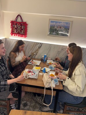 A group of people dining at a table with various food items and drinks.
