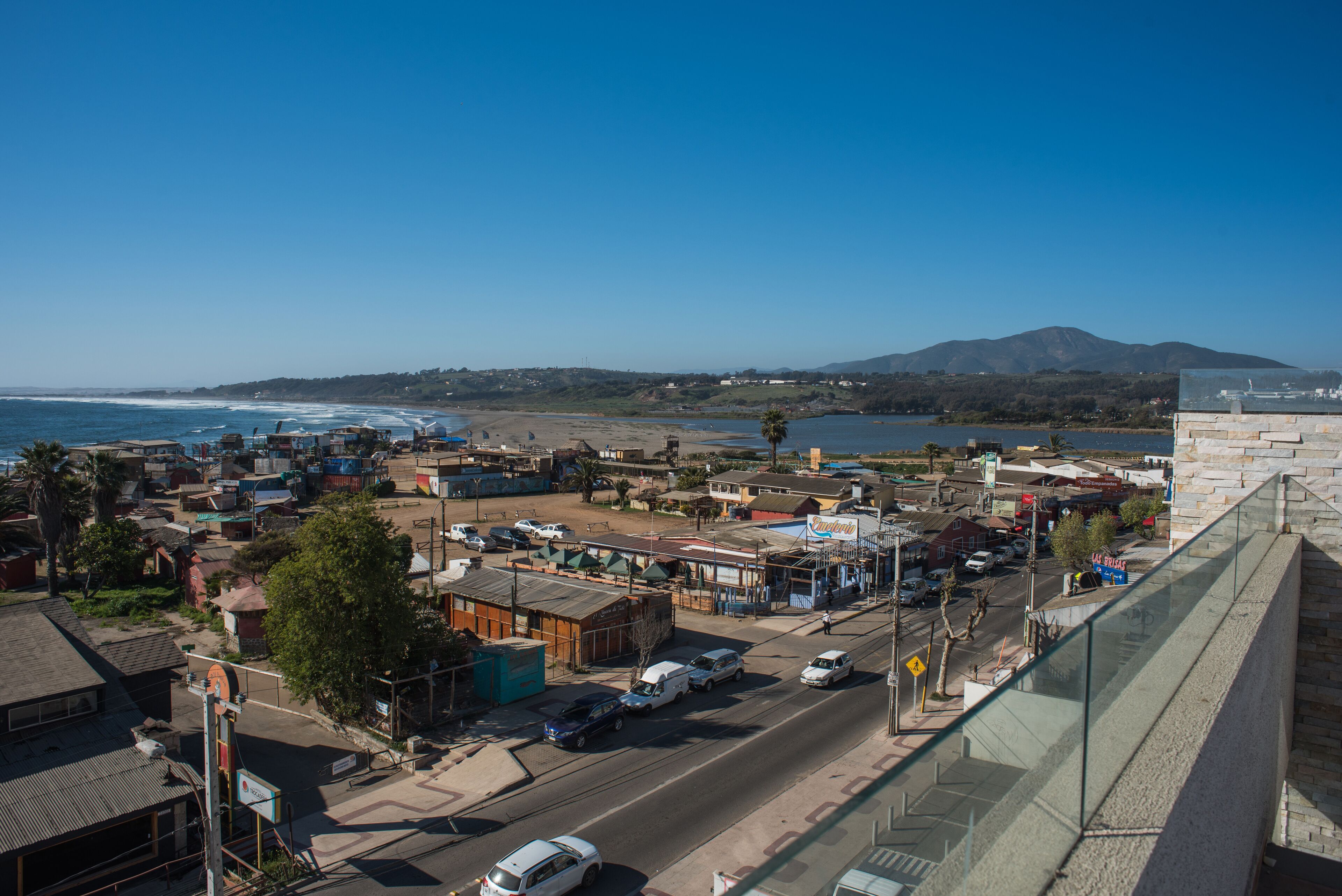 A coastal town with a view of the ocean and a mountain in the distance.
