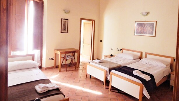 A hotel room with two beds, a desk, and a chair. - Cozy apartment near Chatedral and Medici Chapels (Firenze)