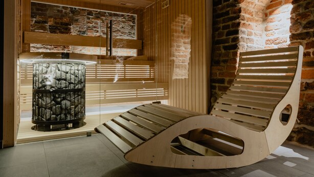 Una sauna moderna con bancos de madera y una pared de piedra.