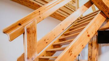 A wooden staircase structure with visible beams and a black object at the bottom.