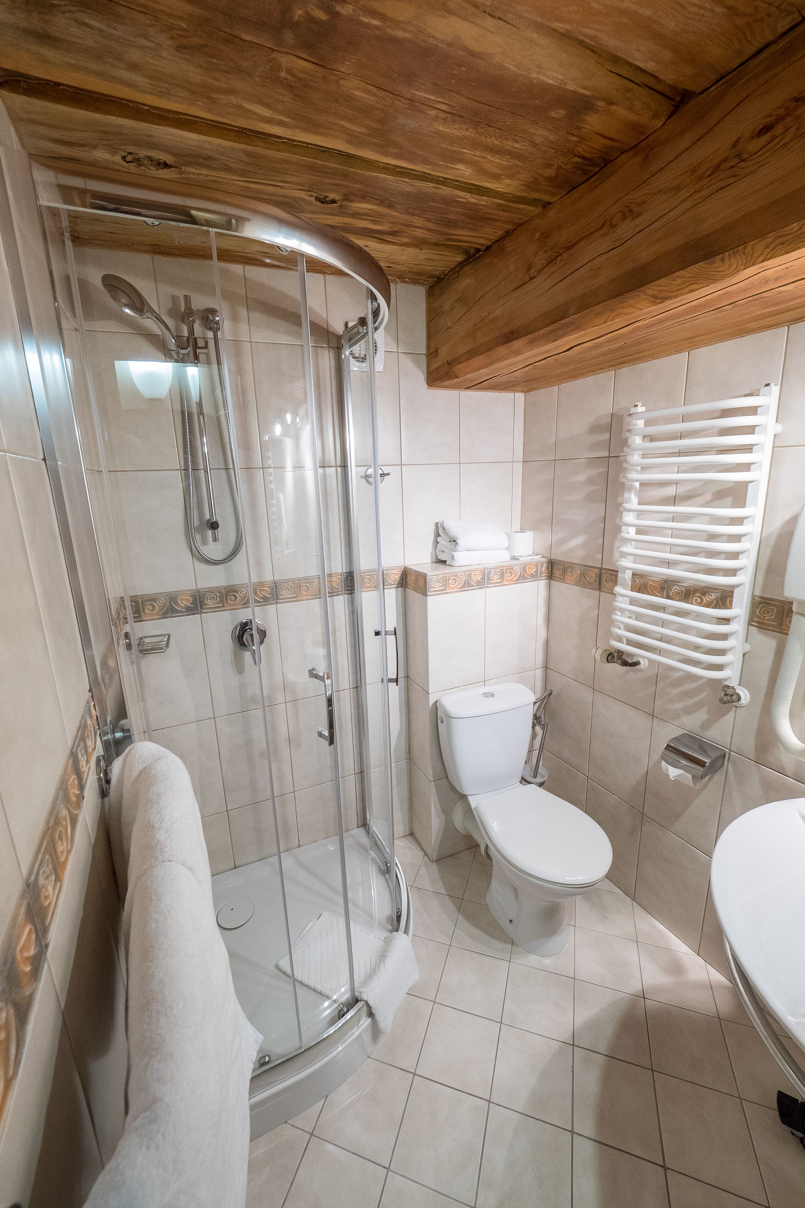 Un baño con cabina de ducha de vidrio, inodoro y lavamanos.