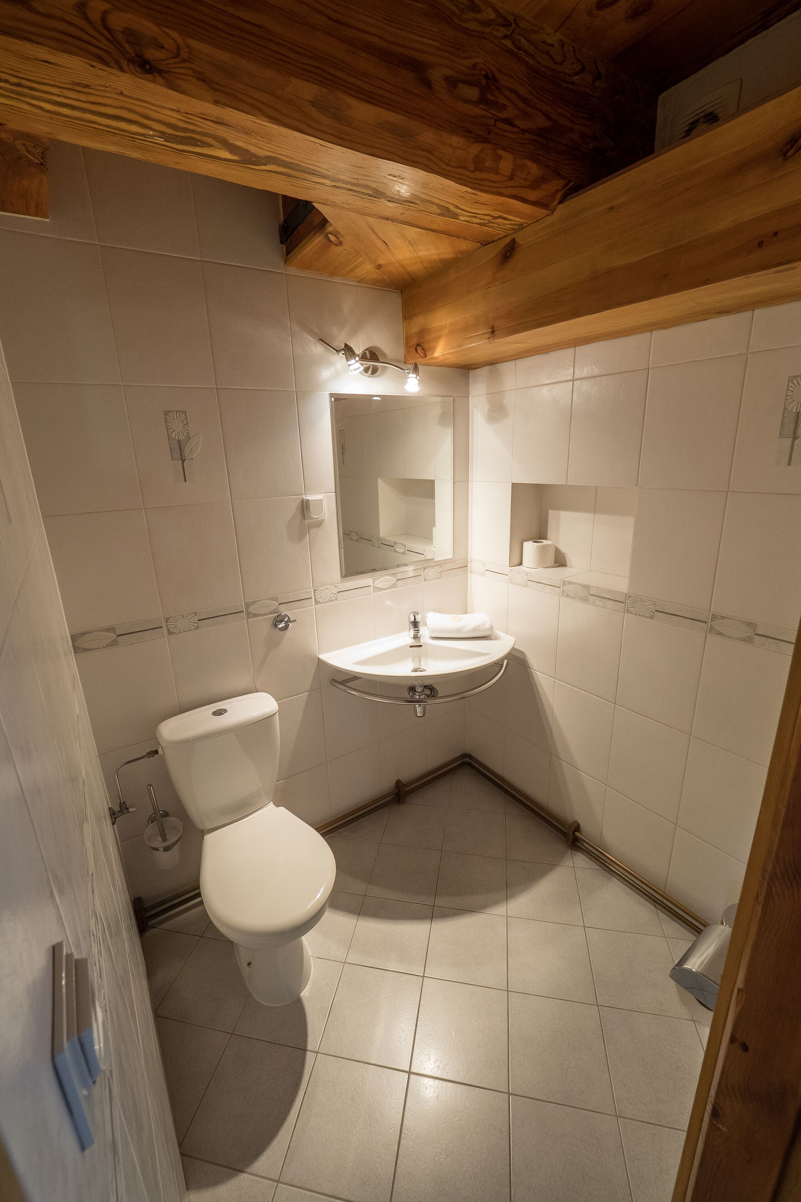 A small bathroom with a toilet, sink, and mirror.