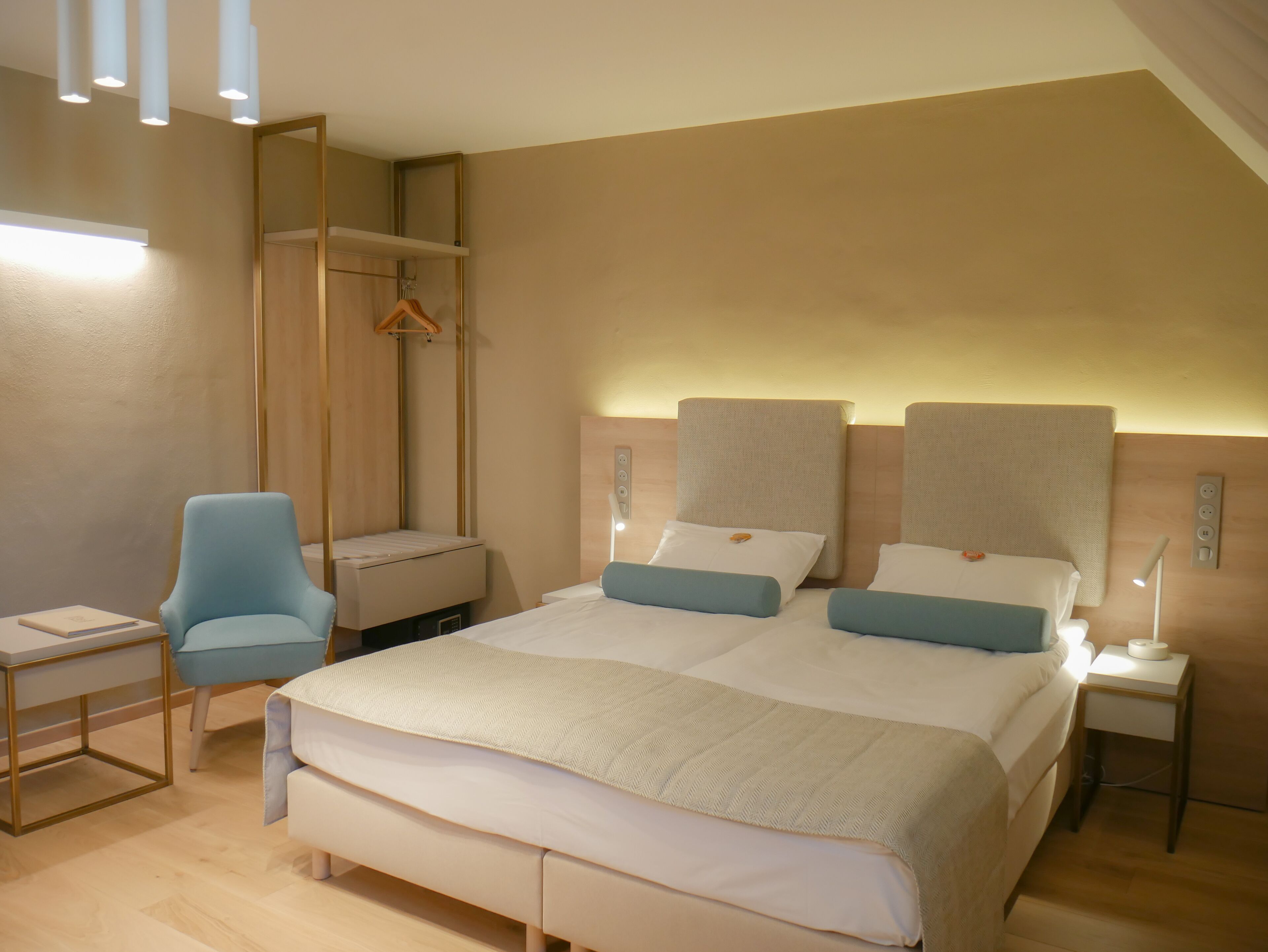 Moderni hotellihuone, jossa on suuri sänky, työpöytä, tuoli ja vaatekaappi.