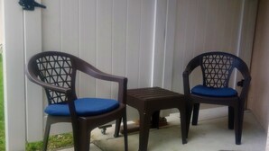 Two chairs with blue cushions and a small table in a covered outdoor area with a white wall in the background. - CLEAN, COMFORTABLE, FULLY PRIVATE UNIT IN GATED COMMUNITY  (Ocala)