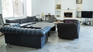 A modern living room with a sectional sofa, a coffee table, and a TV. - Villa Malaga (Carthage)
