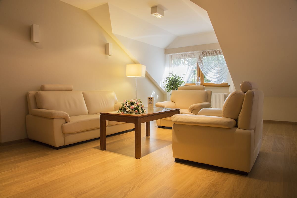 Una sala moderna con sofá, sillón y una mesa de centro con un arreglo floral.