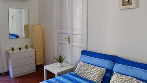 A bedroom with a bed, a dresser, a mirror, and a door. - Hostel Via Zara (Palermo)
