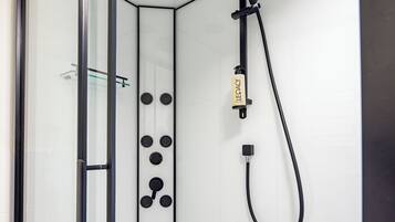 A modern shower with a handheld showerhead and a handheld massager.