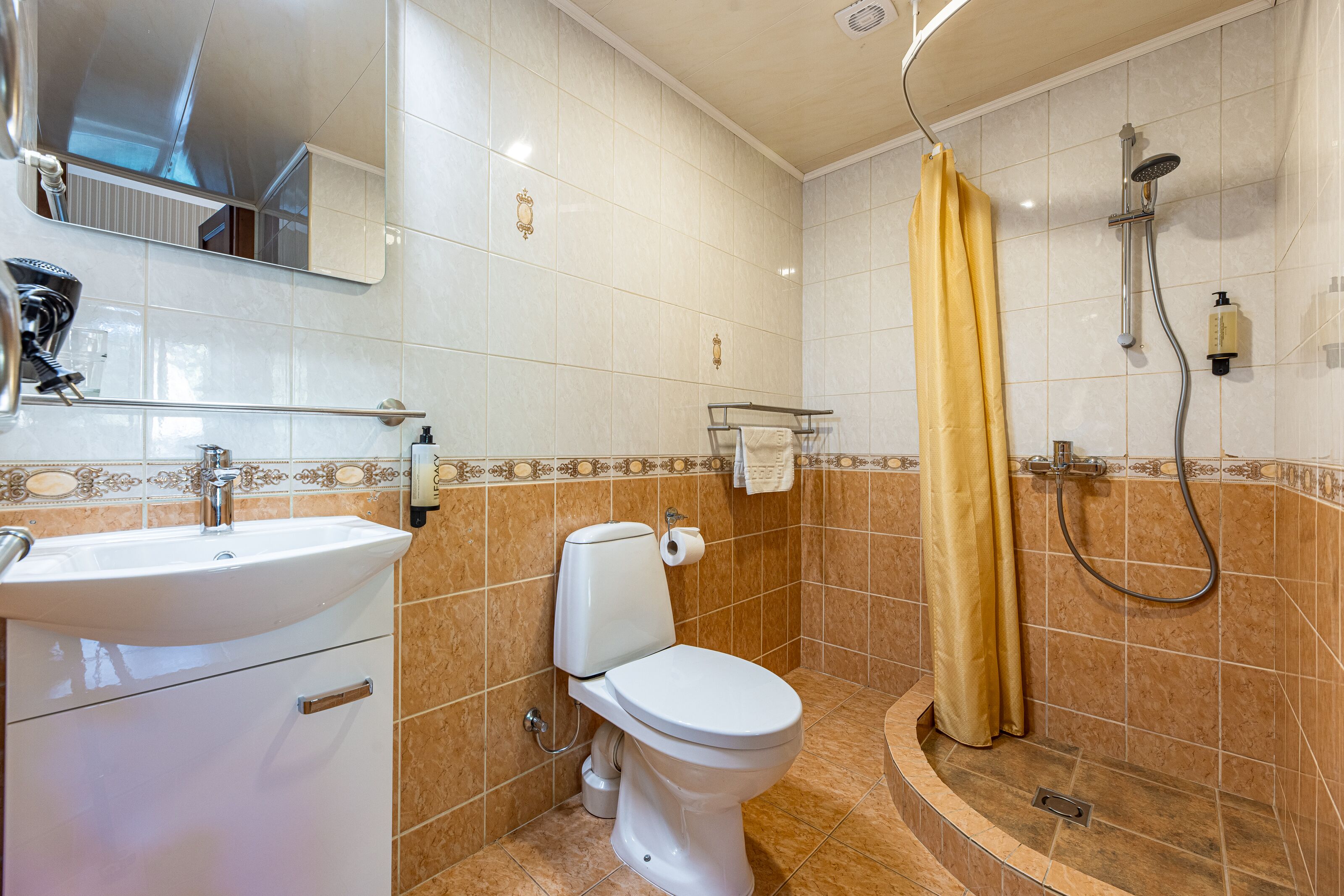 A bathroom with a sink, toilet, and shower.