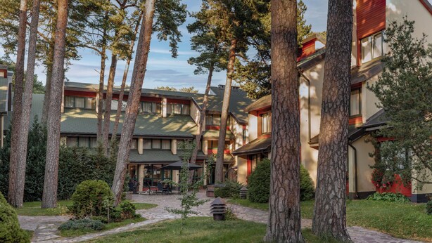 Ein Hotel mit mehreren Gebäuden, einem zentralen Innenhof und Bäumen.