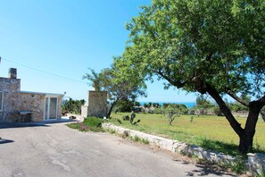 Escape to a serene residence surrounded by a well-manicured lawn and a large tree.