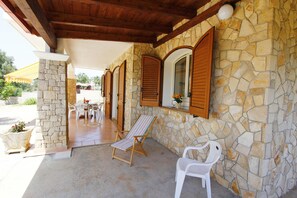 A covered outdoor seating area with stone walls, wooden shutters, and a pool table. - Villetta 54 (Salve)
