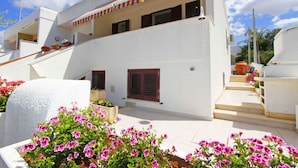 A white building with a balcony, a staircase, and pink flowers in the foreground. - Villetta Rossini (Morciano di Leuca)