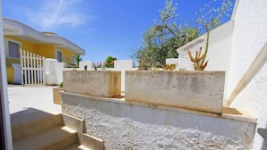 A set of outdoor stairs leading up to a white wall with a textured surface. - Villetta Rossini (Morciano di Leuca)