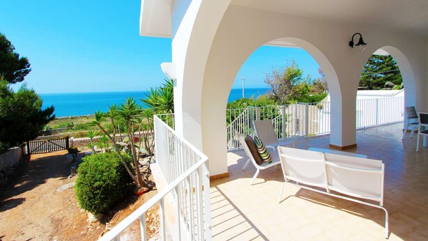 A balcony with white railings, a bench, and a view of the sea. - Villetta Mare 464 (Patu)