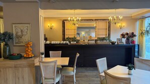 Un comedor con una mesa central, sillas y una barra.