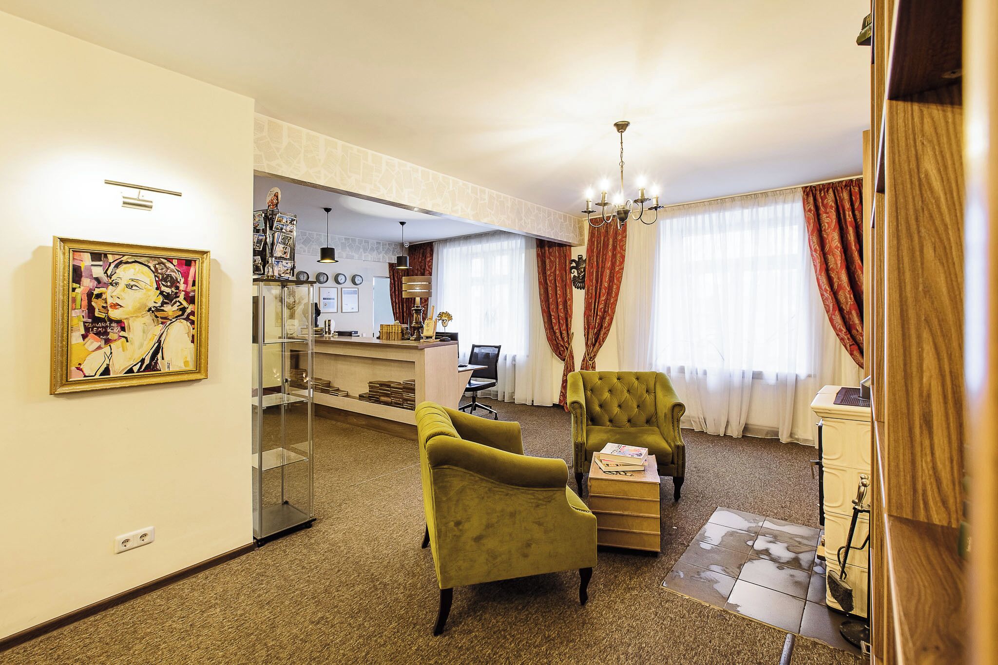 A living room with a sofa, armchairs, a desk, and a painting.