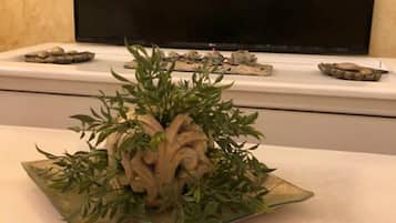 A table with a decorative centerpiece featuring green leaves and beige elements.